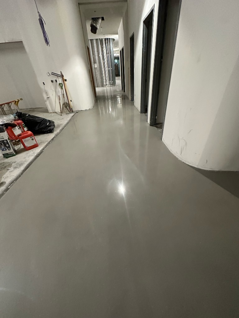 Long hallway with highly reflective polished concrete during construction