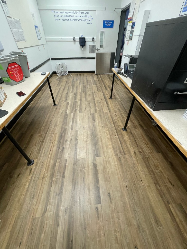 Retail back office with wood-look laminate plank flooring and workstations