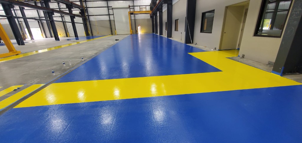 Industrial warehouse interior with glossy blue and yellow epoxy floor markings
